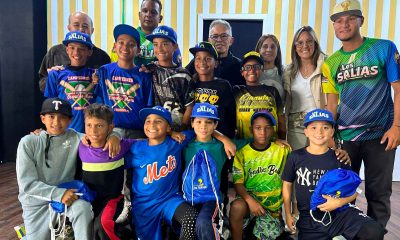 El alcalde José Fernández entregando uniformes al equipo Sub-11 de béisbol menor Los Salias, rodeado de jugadores y miembros de la comunidad.