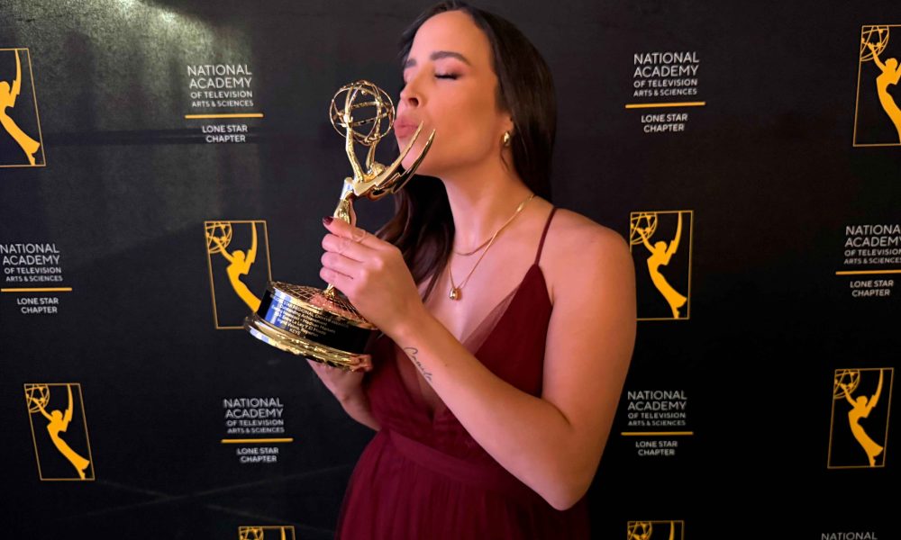 Ingrid Caribay Valero, radiante, sosteniendo su Emmy Lone Star 2024. Su sonrisa refleja el éxito y la perseverancia.