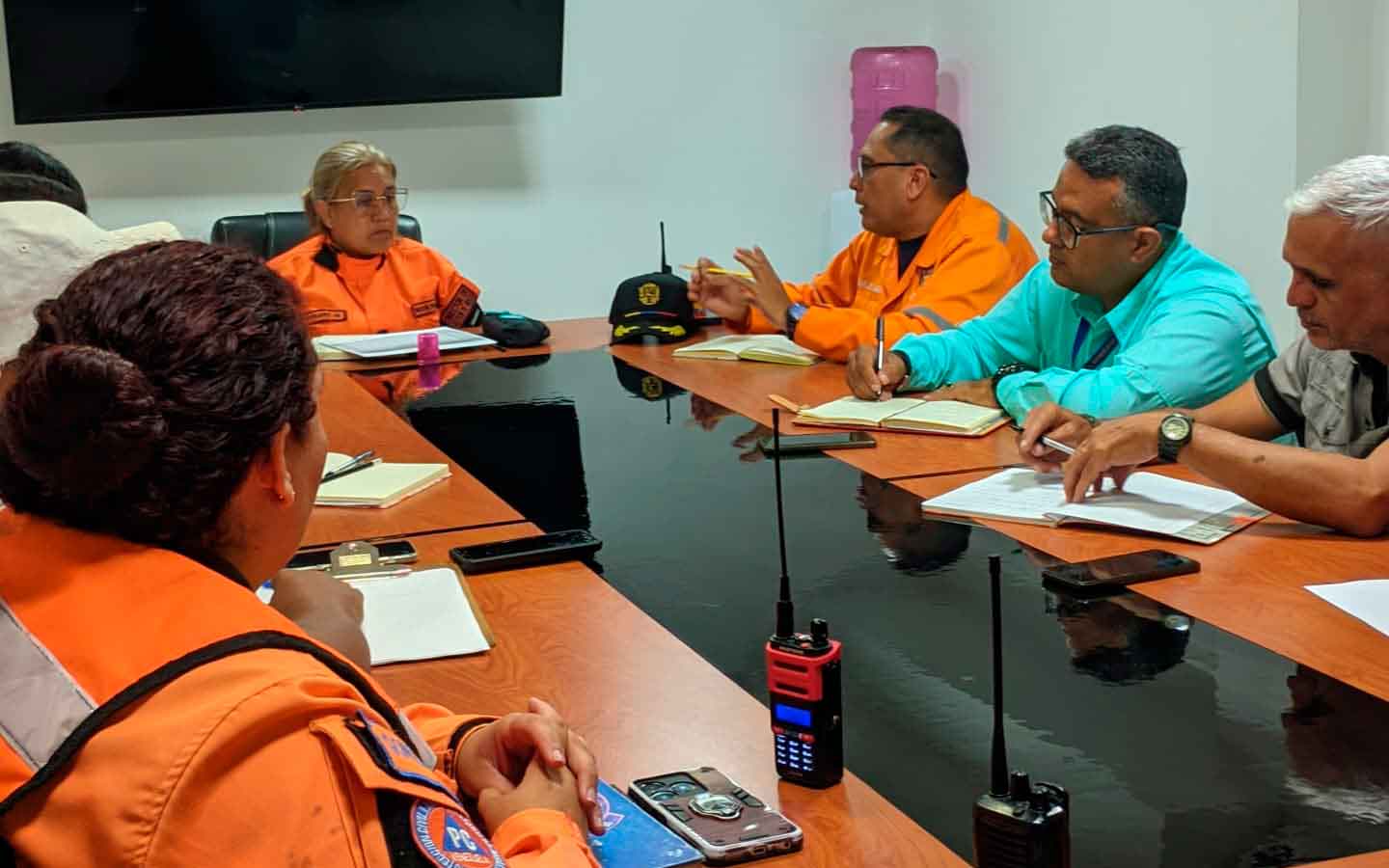 Funcionarios de Protección Civil y autoridades locales revisando un mapa de zonas de riesgo en Carrizal.